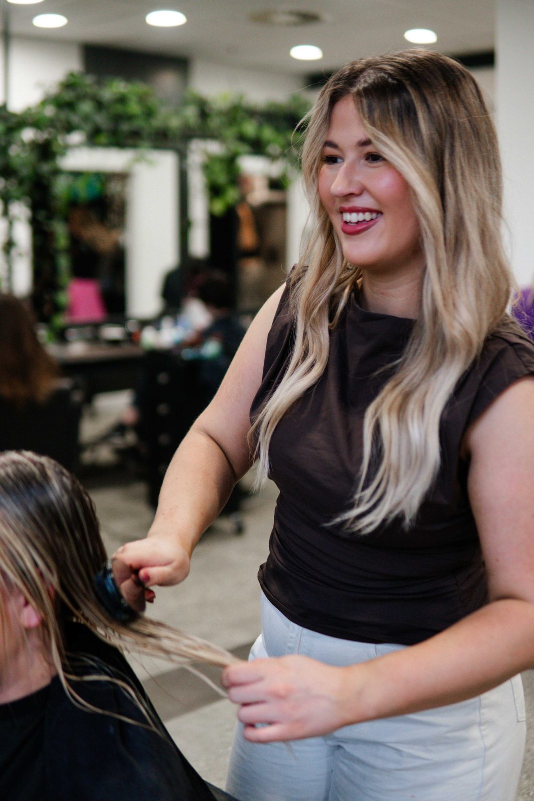 Stylist combing through freshly washed hair at Iron + Ivy Hair Studio, Queenstown