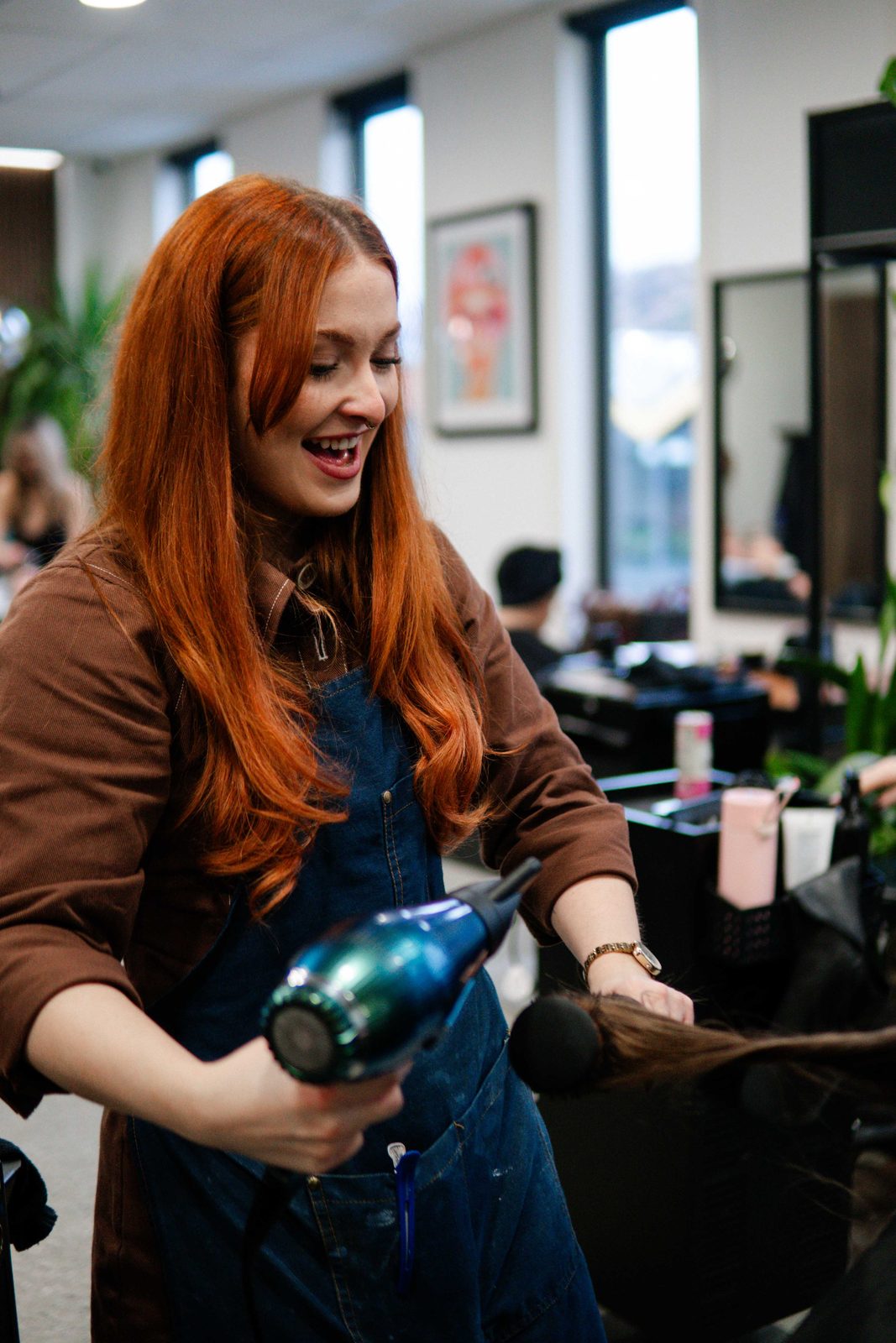 Stylist blow-drying a client at Iron + Ivy Hair Studio, Queenstown