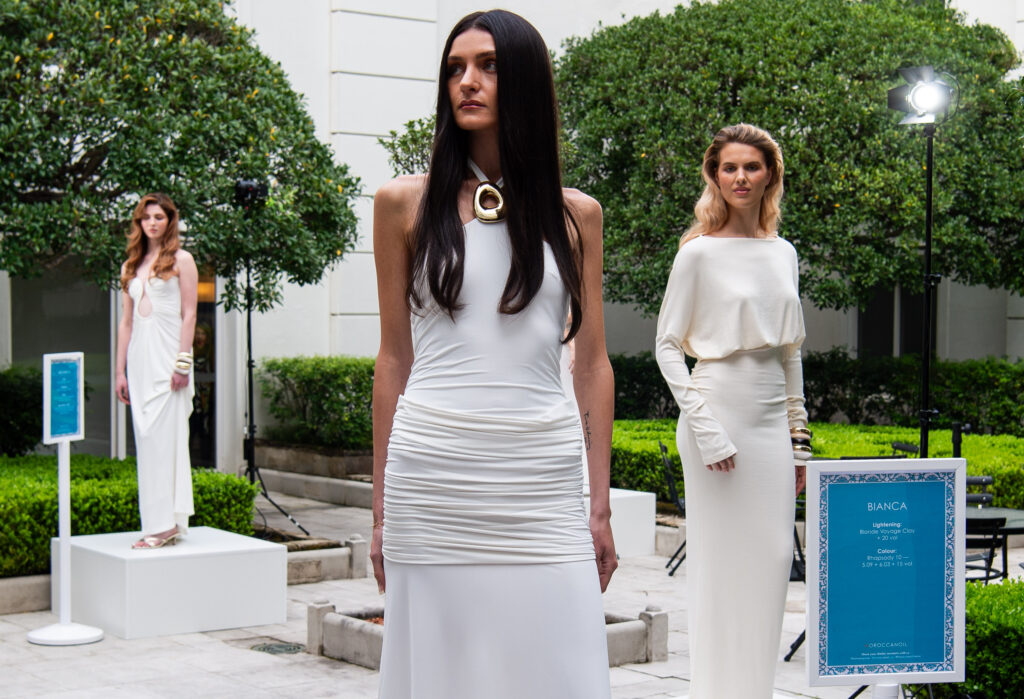Models in white showcasing Moroccanoil colour work in a courtyard at the Moroccanoil Atelier conference in Sydney